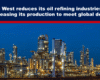Expose News Oil refinery at night with bright lights against a blue sky, highlighting Asia's increase in production as Western industries reduce output.