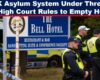 Police officers in high-visibility jackets stand outside The Bell Hotel in Essex, the site of protests and a court ruling on housing asylum seekers.