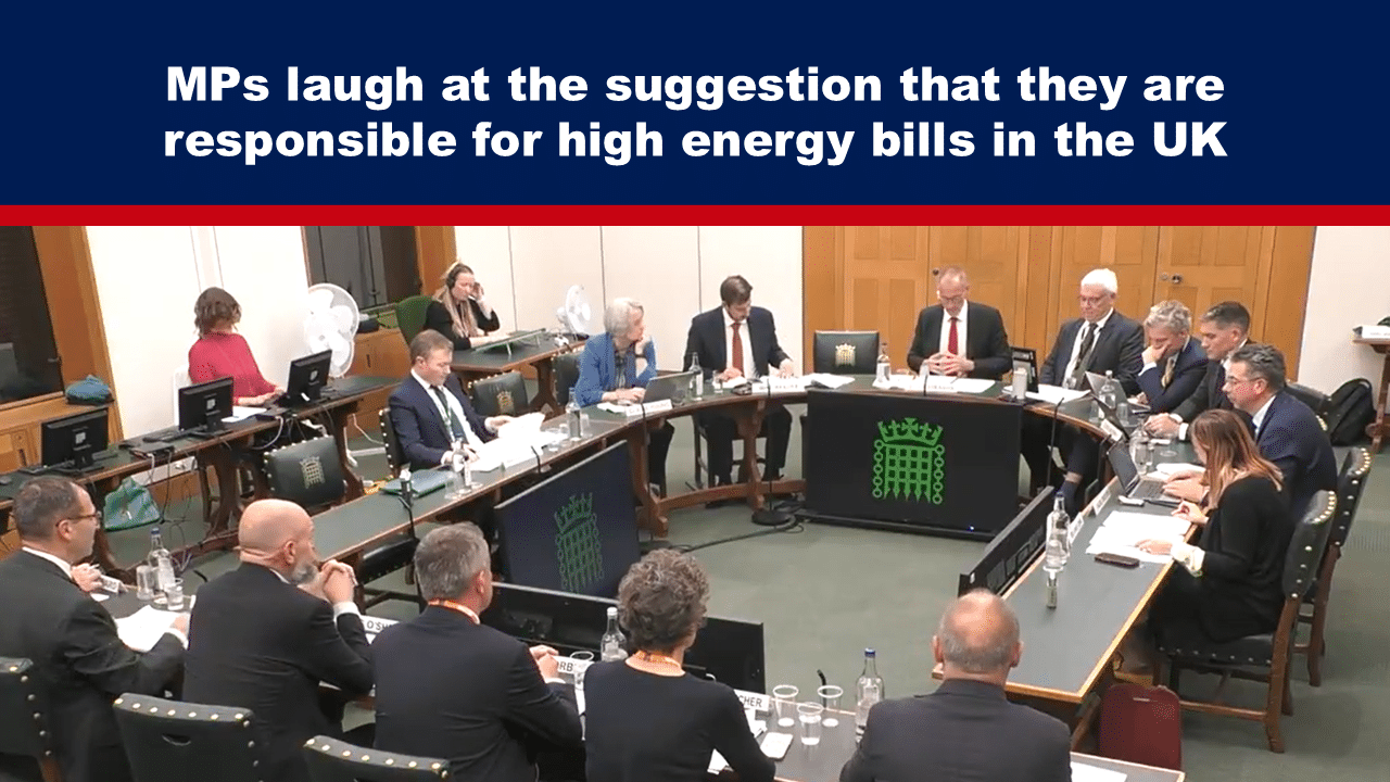 Expose News: MPs in lively debate, chuckling at claims of blame for UK's high energy bills, captured in a lively parliamentary scene.
