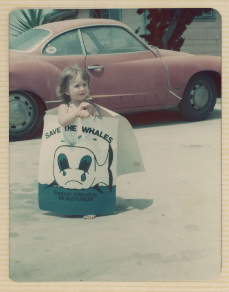 Expose News: Adorable child holding a 'Save the Whales' sign, a symbol of hope in a world facing climate challenges. Can we save our planet?