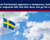 Swedish flag waving on a tall flagpole against a blue sky with clouds; used for a migrants bill article header.