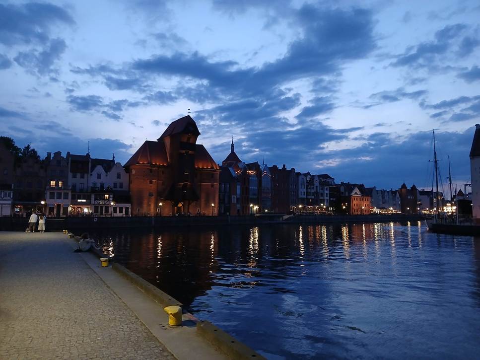 image - The Expose Harbor at dusk with historic brick buildings along a canal and their reflections in calm water.