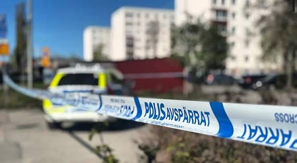 image - The Expose Swedish police tape cordoning off an urban area with a police car blurred in the background