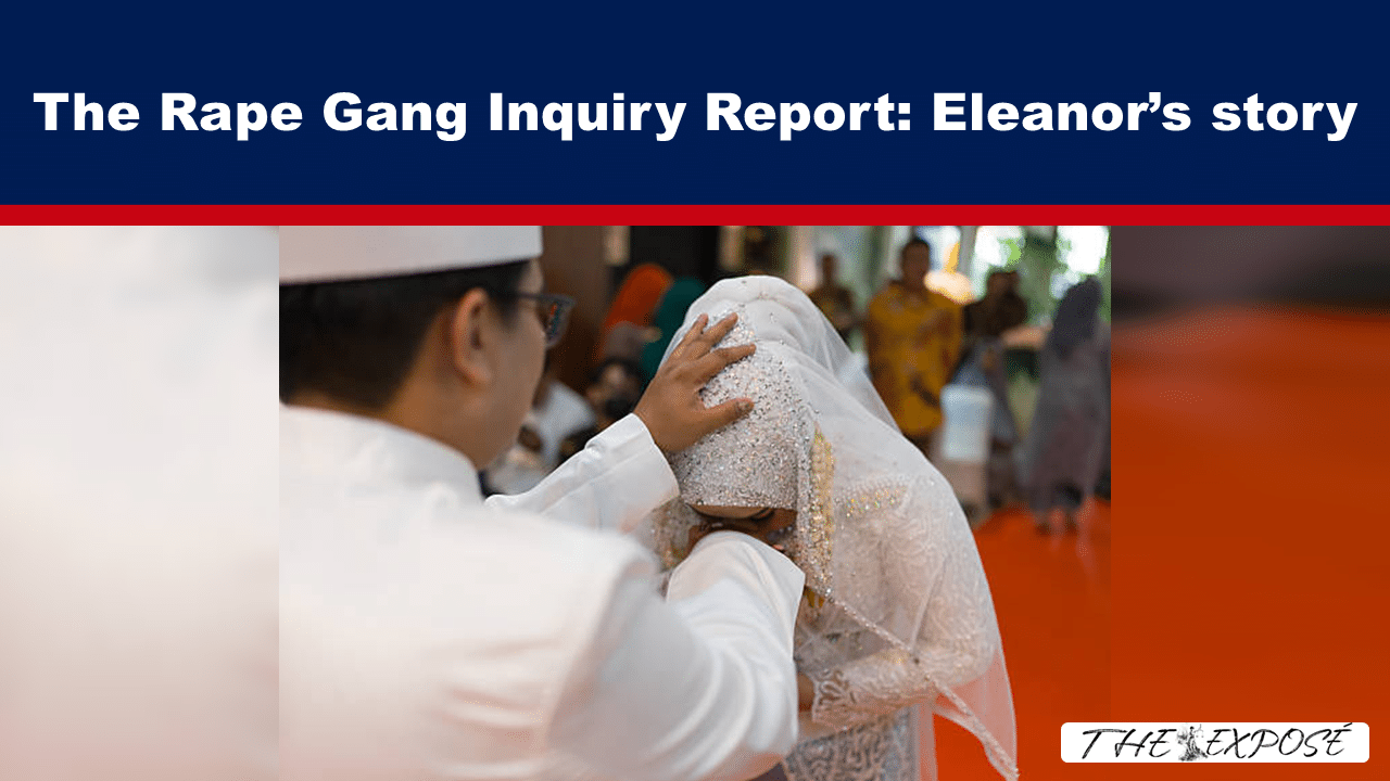 A groom in white coats the bride's head veil with his hand during a wedding scene, with guests in the background and an orange floor.”