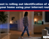 Living room scene with a Wi‑Fi router on a table and colorful lines tracing toward a walking woman, illustrating in‑home device identification by the router in Comcast’s feature.