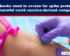 Close-up of a medical professional in purple gloves giving a vaccine injection into a person’s upper arm, with a pink strap visible on the arm.