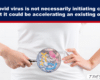 Close-up of a person in a white shirt holding a magnifying glass to their abdomen, highlighting abstract colorful shapes representing cancer/gut research.