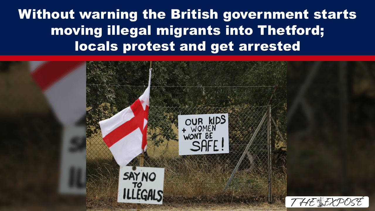Protest scene with handwritten signs on a chain-link fence: 'Our kids and women won’t be safe' and 'Say no to illegals', plus a red-and-white flag nearby.